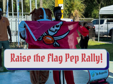  Rocky the Bulldog and Ms Copeland hold a Bucs flag
